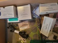 Box with multiple small Creative Memories branded boxes and plastic bags containing scrapbooking tools