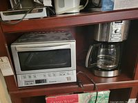 Panasonic toaster oven and Cuisinart coffee machine on wooden shelf