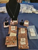 Lot showing 7 pieces of jewelry including necklace on stand and multiple rings and earrings in original sealed bags with seller tags.