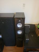 Energy tower speaker and Kenwood tower speakers side by side, covers removed; multiple drivers visible on Kenwood speaker