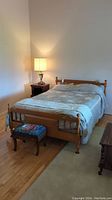Full assembled full size bed with wood headboard, footboard, metal rails and bedding