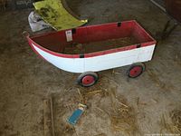 Side view showing boat-shaped metal body painted white with red top border and four wheels