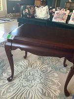 Full view of wood occasional table showing rich dark finish and removable cabriole legs.