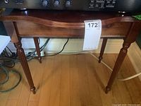 Front and top view showing table with curved apron and four carved pencil legs.