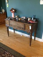 Front view of spinet desk showing two drawers, carved apron and fluted legs