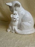 Photo showing front view of the white ceramic cat and kitten figure with textured fur detail and painted eyes.