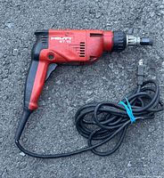 Side view of HILTI ST-18 corded torque screwdriver showing red and black handle, venting slots, and cord with plug.