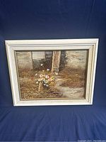 Frontal view of oil painting depicting flowers in bucket against rustic door background in white frame.