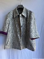 Front view of Etro Milano vintage jacket showing intricate black and white floral paisley pattern and purple sleeve cuff.