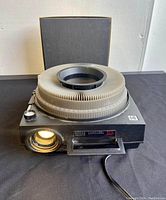 Front and top angled view of the Kodak Carousel 650H slide projector with 140 slide carousel tray on top.