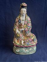 Front view of the antique Chinese Guanyin porcelain figure seated on lotus base, showing intricate Famille Rose floral decoration and gold detailing.
