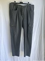 Front view of grey women's cargo pants with button fly, pockets, and belt loops