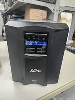 Front view of APC Smart-UPS 1500 showing LCD control panel with 'Output Off' and battery status on screen.