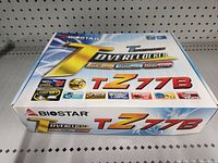 Closed retail box of Biostar T Z77B Overclocker motherboard photographed on shelf.