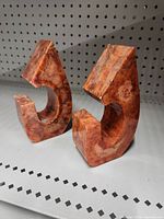 Pair of curved abstract marble bookends showing front sides with chips