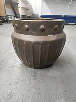 Front and side view of large decorative brass pot with riveted rim and vertical ridges on rounded body.