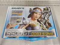 Box of Gigabyte NVIDIA GeForce 9500 GT DDR3 512MB graphics card with gaming artwork and specifications