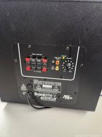 Rear view showing speaker connections, low level input, power and volume control, power cord.