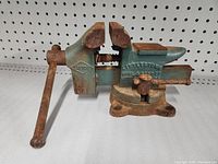 Side angle view of the Litco bench clamp showing the clamp jaws, handle, and rust on the base and screw mechanism.