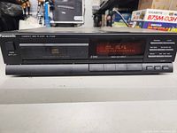 Front view of Panasonic SL-PJ324 CD player showing display, control buttons, and tray.