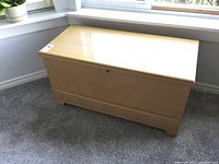 Front and side view of the light wood cedar chest showing the detailed wood grain and chest design.