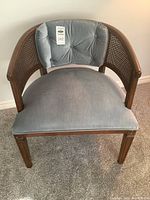 Front view of blue fabric upholstered side chair with wooden frame and rattan style arms, showing overall condition and design.