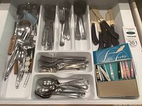 Image showing organized cutlery tray with various utensils including spoons, forks, knives, ladles, and boxed colorful h'ordeuvre forks