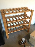 Front view of the wooden wine rack showing 4 slatted shelves and natural wood finish.