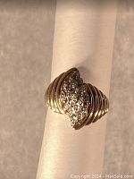 Front view showing white gold diamond cluster and yellow gold grooved shoulders