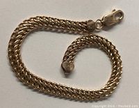 Coiled view of the double curb link bracelet showing chain style and lobster clasp.