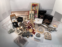 Wide view of assortment showing jewelry, rosaries, medallions, charms, and vials