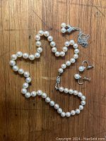 Full lot on wood background: pearl strand, screw-back earrings, chain and pendant