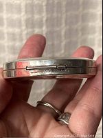 Close-up of side view showing Tiffany & Co., 925 sterling markings beneath the hinge on the compact mirror.