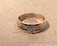 Front view of two-tone gold band with marquise-shaped diamond.
