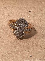 Front three-quarter view showing dual cluster diamond heads atop yellow gold band