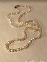 Entire necklace laid out on flat surface showing bead graduation and clasp detail.