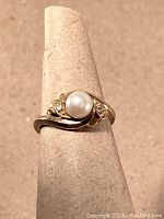 Front view on ring cone stand showing bypass design with pearl and diamonds