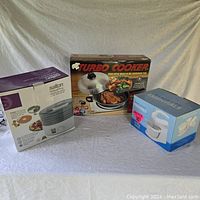 All three original boxed appliances are displayed on a table: Salton Vita Pro dehydrator, Turbo Cooker, and Everyday Essentials stand mixer.