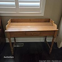 Front view of rustic pine hall table showing single drawer and turned legs.