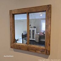Full view of square framed mirror with natural wood finish and two glass panels mimicking a window.