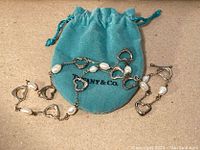 Necklace with open heart links and freshwater pearls displayed with Tiffany & Co pouch
