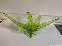 Side view of 1970s light green chalet glass bowl with three extended curved points and clear glass feet