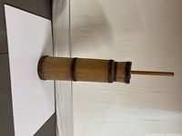 Full view of the assembled wooden butter churn with handle on a white backdrop.
