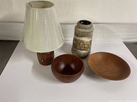 Photo showing Mid-Century Modern teak lamp with white fabric shade, two wooden bowls, and ceramic vase.