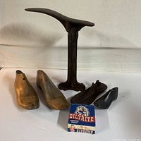 Group photo showing all items together: two wooden shoe molds, metal shoe stand, small black metal shoe form, and boxed Biltrite rubber heels.