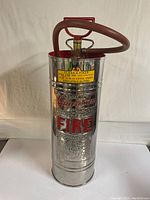 Front view showing chrome body, embossed logo and attached hose