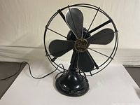 Front view showing five-blade fan with protective guard on white surface