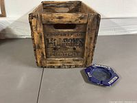 Wooden beer bottle crate with 'Property of Molson's Brewery' stenciled text visible, accompanied by a blue enamel ashtray with 'Molson's Ale Porter' text.