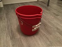 Three red plastic buckets stacked together, showing the entire lot