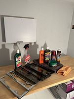 Overview of car care products including bottles, license plate frames, and cloths on wooden surface